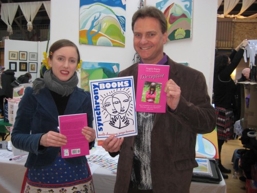 Clare Galloway and Eric Swanepoel display the Synchrony Books logo, designed by Clare, and copies of 'Disruptive', the cover of which was designed by Vroni Holzmann.